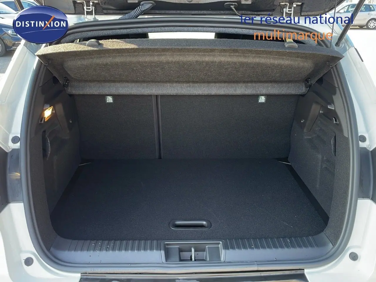 Coffre ouvert d'un Renault Captur blanc nacré avec toit gris, vue arrière montrant l'espace de chargement vide.