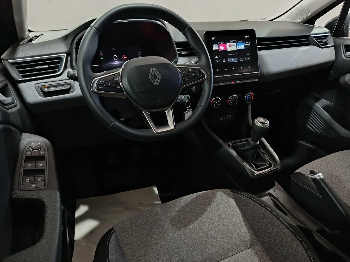 Vue intérieure avant de la Renault Clio gris clair, volant cuir multifonctions et écran tactile central de 7 pouces.