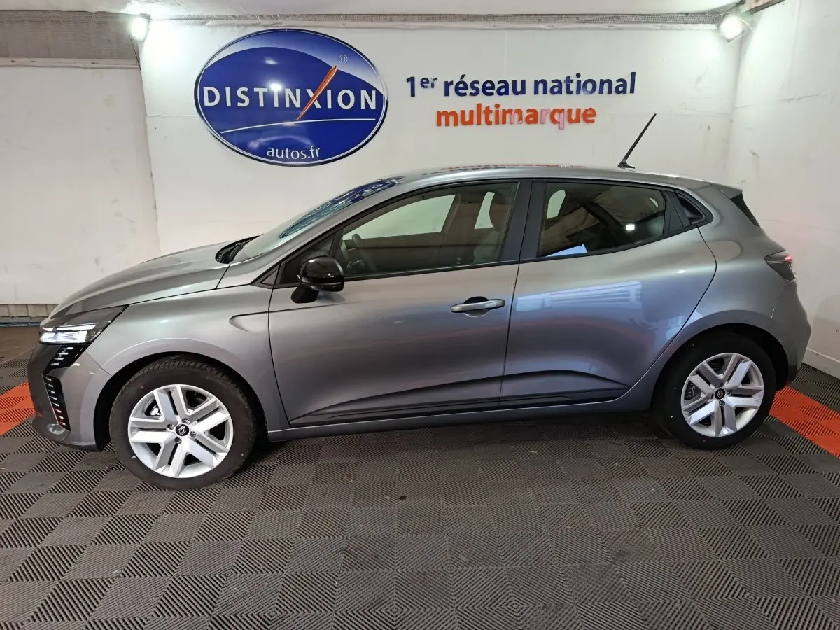 Profil latéral droit de la Renault Clio Evolution Blue dCi 100 gris clair, avec jantes alliage et feux LED visibles.
