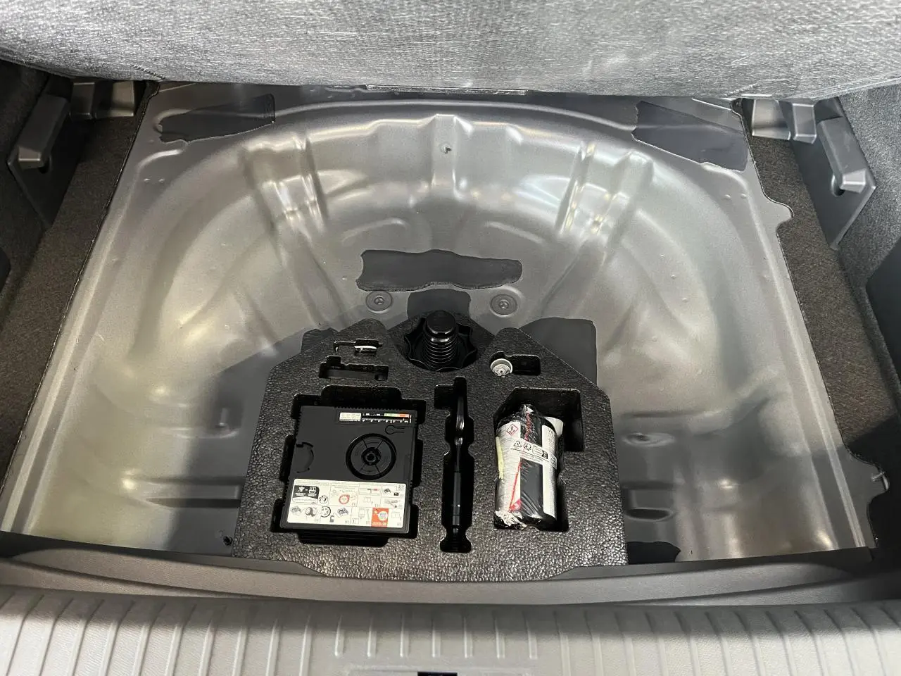 Vue plongeante sur le coffre ouvert du CUPRA Formentor gris clair, montrant le compartiment rangement sous plancher.