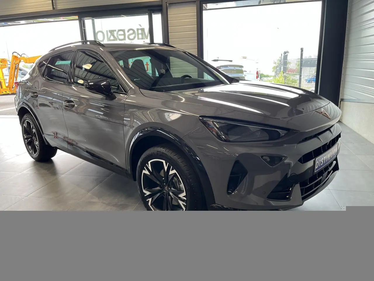 Vue 3/4 avant droite du CUPRA Formentor gris clair avec jantes noires et éléments contrastants noirs obsidien.