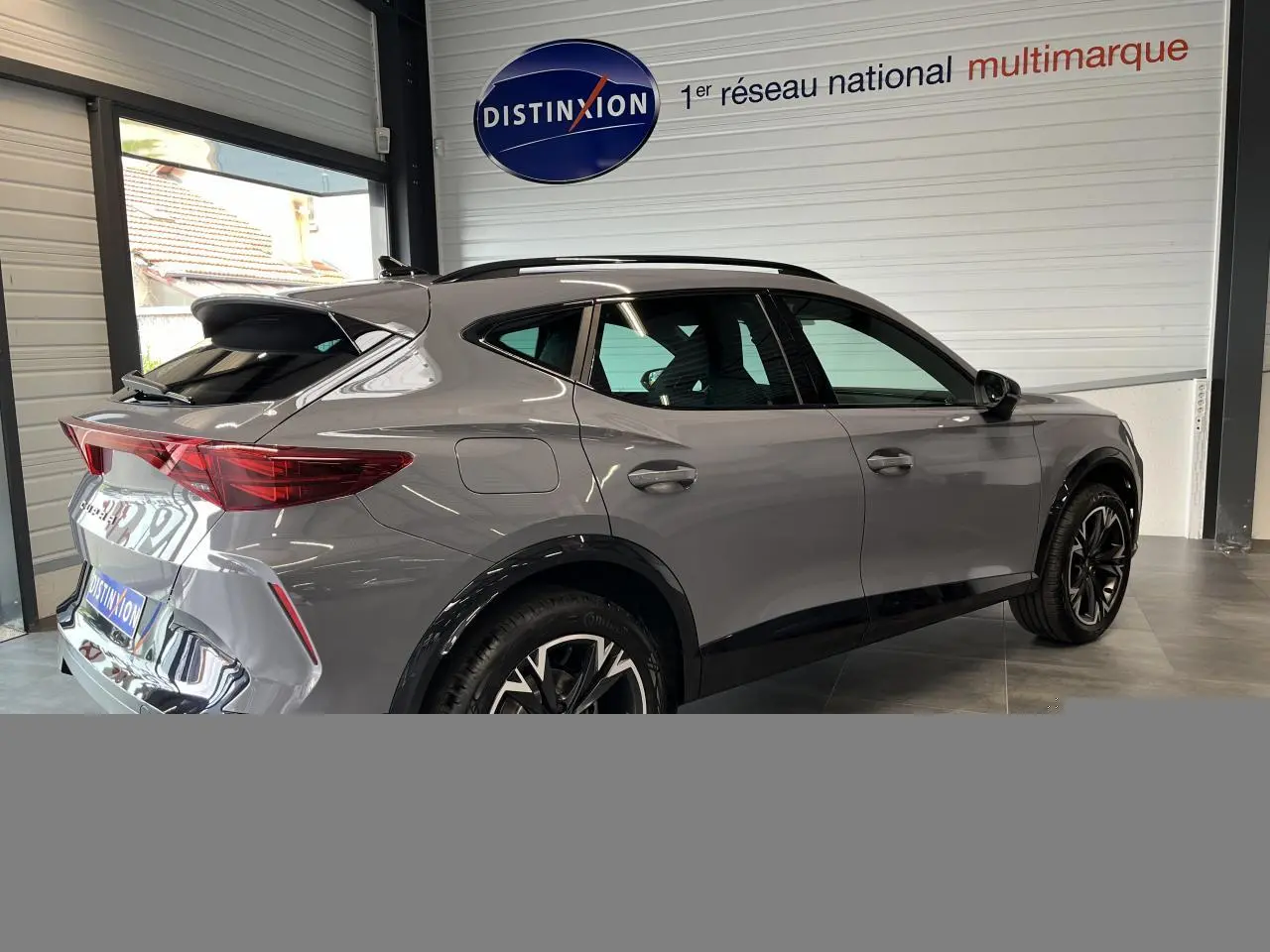 Vue 3/4 arrière droite d'une CUPRA Formentor gris clair avec jantes alliage noires et éléments noirs contrastants.