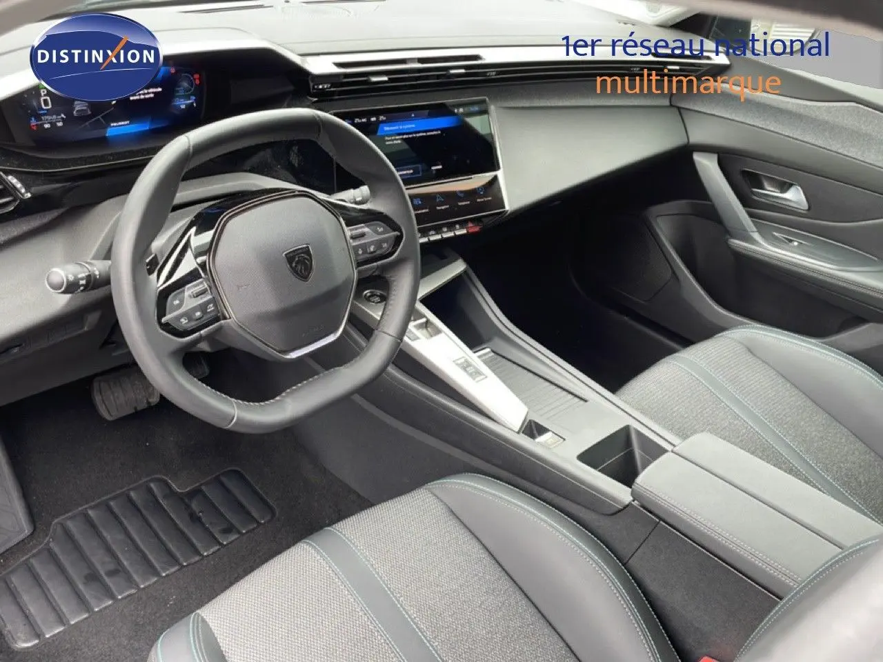 Vue intérieure de la Peugeot 408 2025 montrant le volant, tableau de bord numérique et sièges gris tissu et cuir.