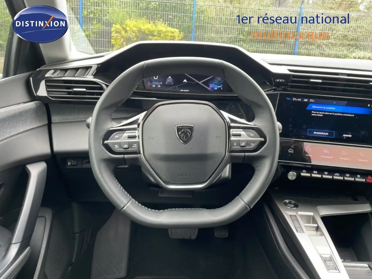 Vue intérieure centrée sur le volant cuir noir et le tableau de bord numérique de la Peugeot 408 gris selenium 2025.