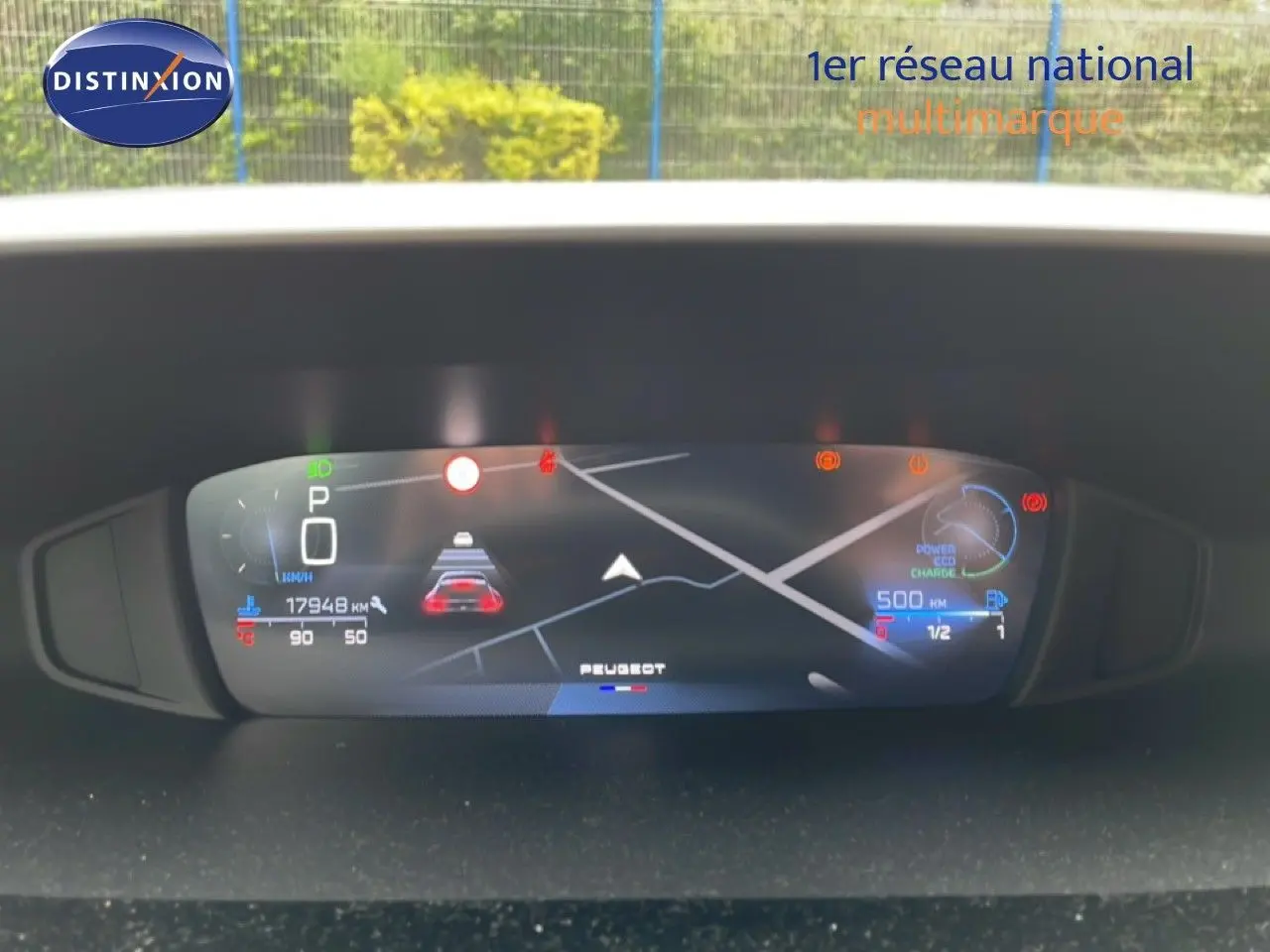 Tableau de bord numérique de Peugeot 408 gris, affichant la navigation et les alertes, vue frontale rapprochée.