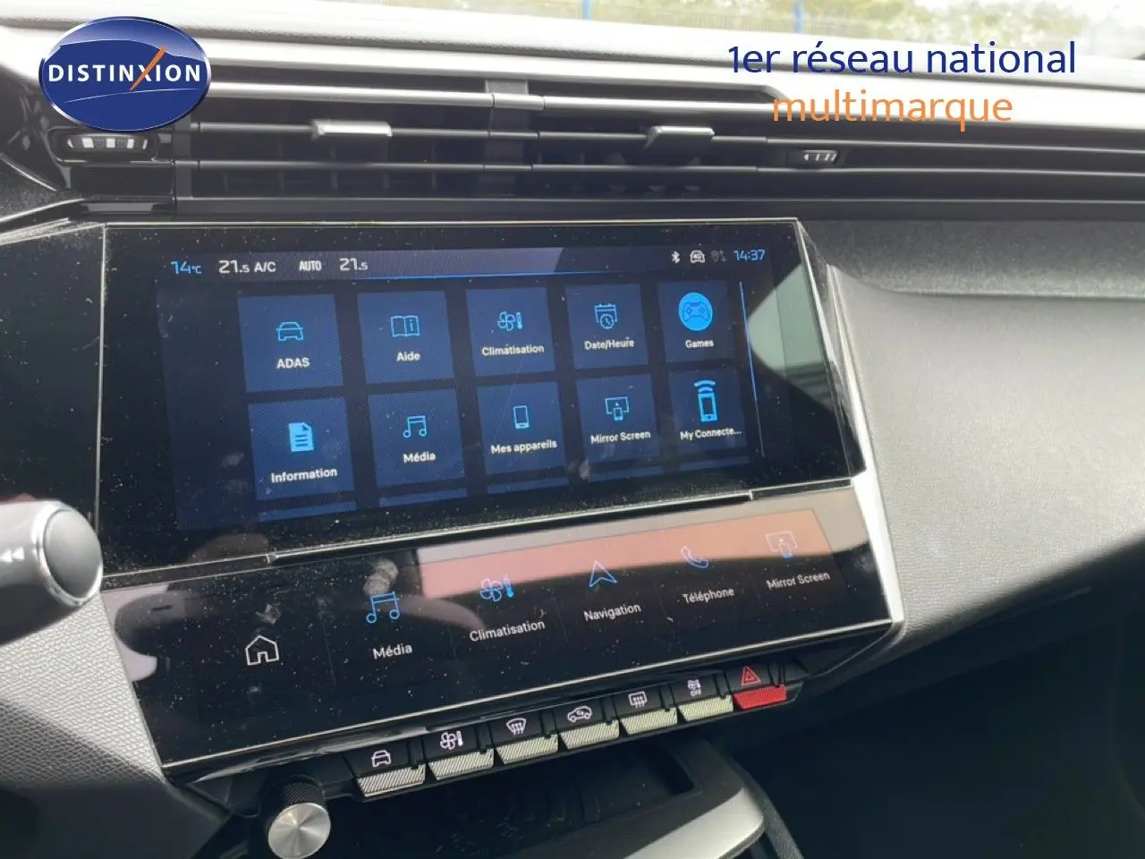 Vue rapprochée de l’écran tactile central du tableau de bord du Peugeot 408 gris, affichant les menus multimédias et climatisation.