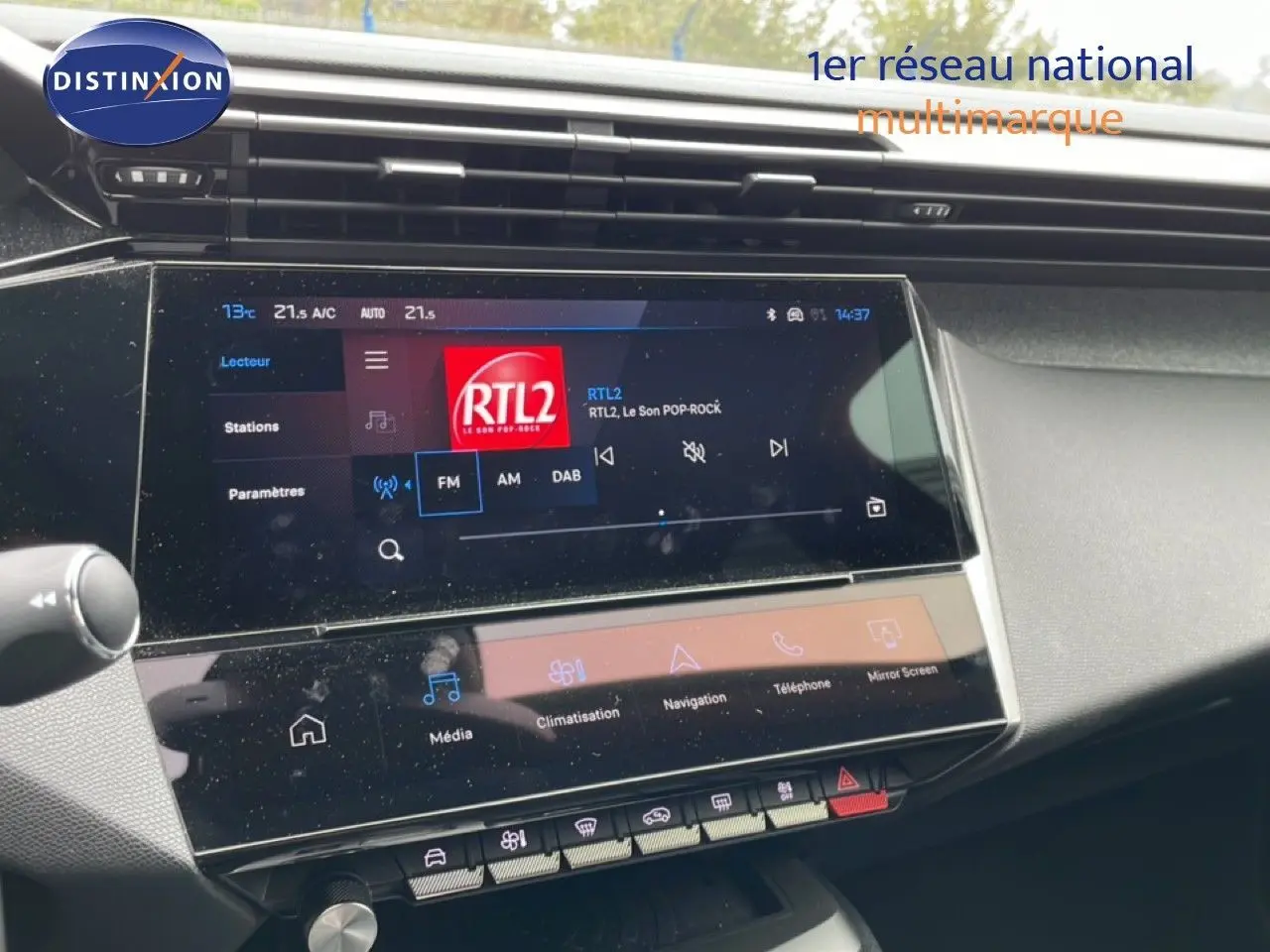 Vue rapprochée de l’écran tactile central de la Peugeot 408 gris Selenium Metal, affichant la radio RTL2.