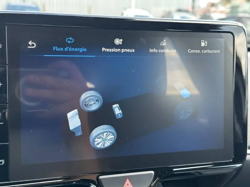 Écran tactile intérieur montrant le flux d'énergie hybride de la Toyota Yaris 116h Dynamic 2025 en Blanc Lunaire.