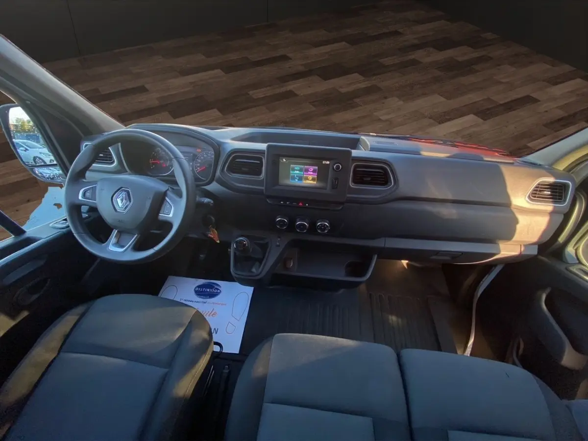 Vue intérieure avant du Renault Master blanc 2023, tableau de bord avec écran tactile et volant multifonction.