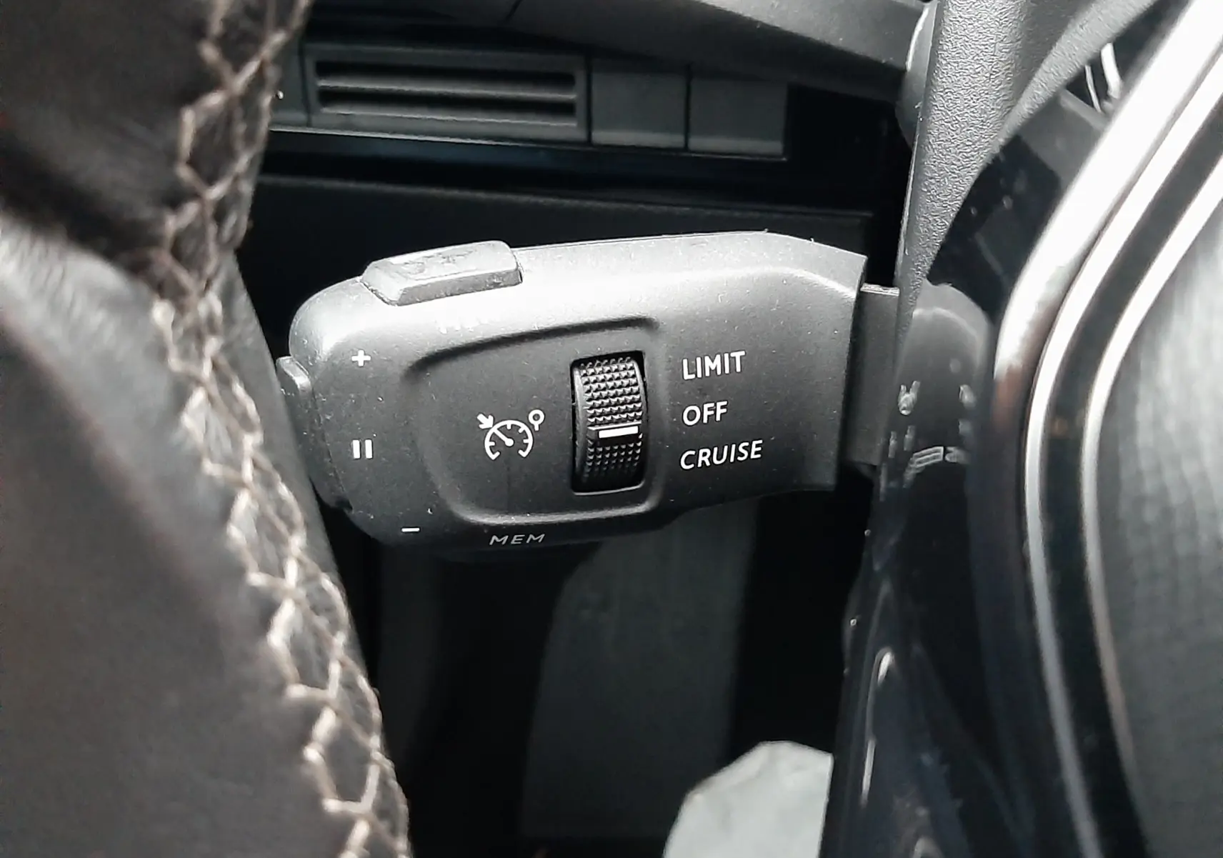 Gros plan sur la commande de régulateur de vitesse à gauche du volant d’un Peugeot 508 blanc de 2018.