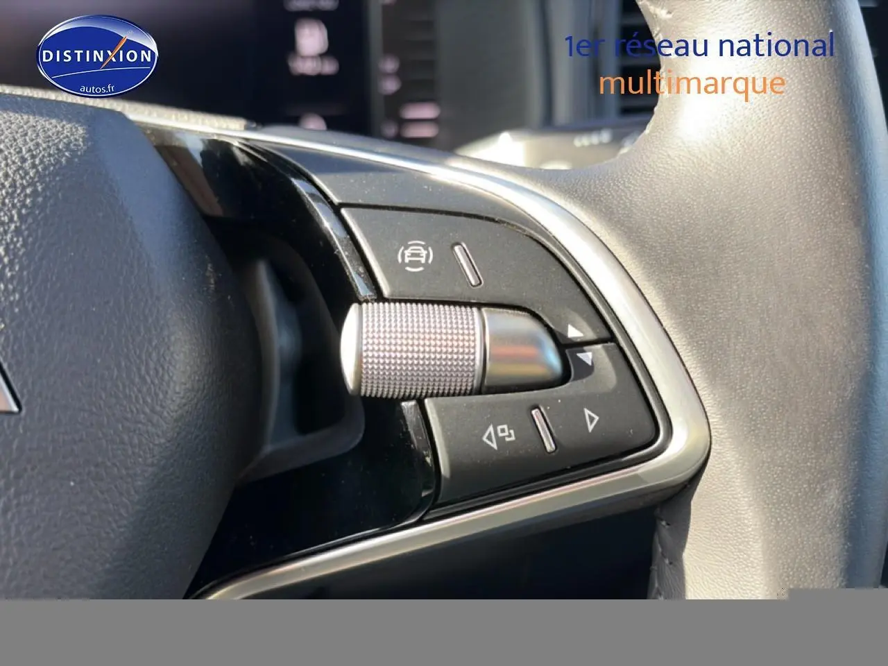 Gros plan sur les commandes multifonctions en métal et plastique noir du volant cuir d'une Skoda Karoq gris 2025.