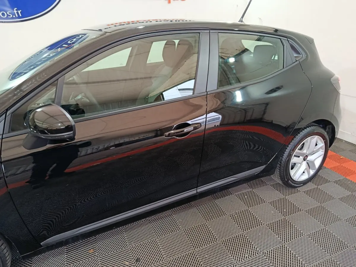Profil côté gauche d'une Renault Clio noire 2025 avec jantes alliage et rétroviseurs noirs brillants.