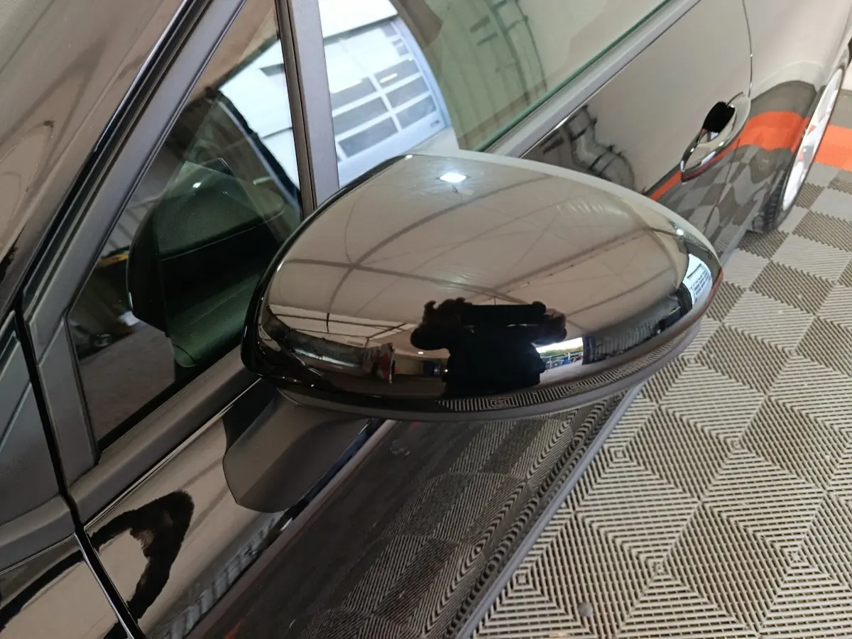 Rétroviseur côté conducteur noir brillant de la Renault Clio Evolution Blue dCi 100 vue en gros plan depuis l'avant gauche.