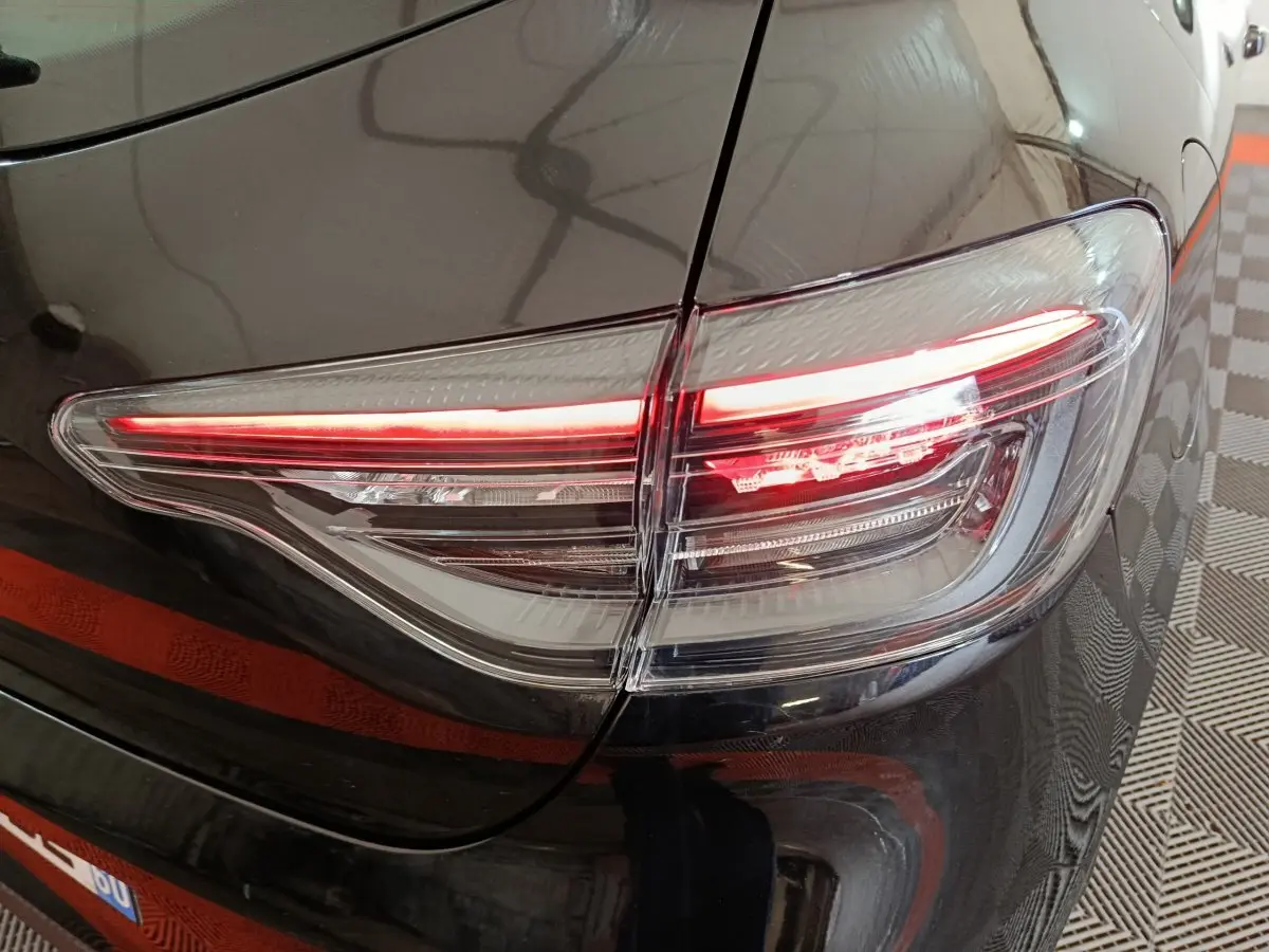 Gros plan sur le feu arrière droit allumé d'une Renault Clio noire Evolution Blue dCi 100 de 2025.