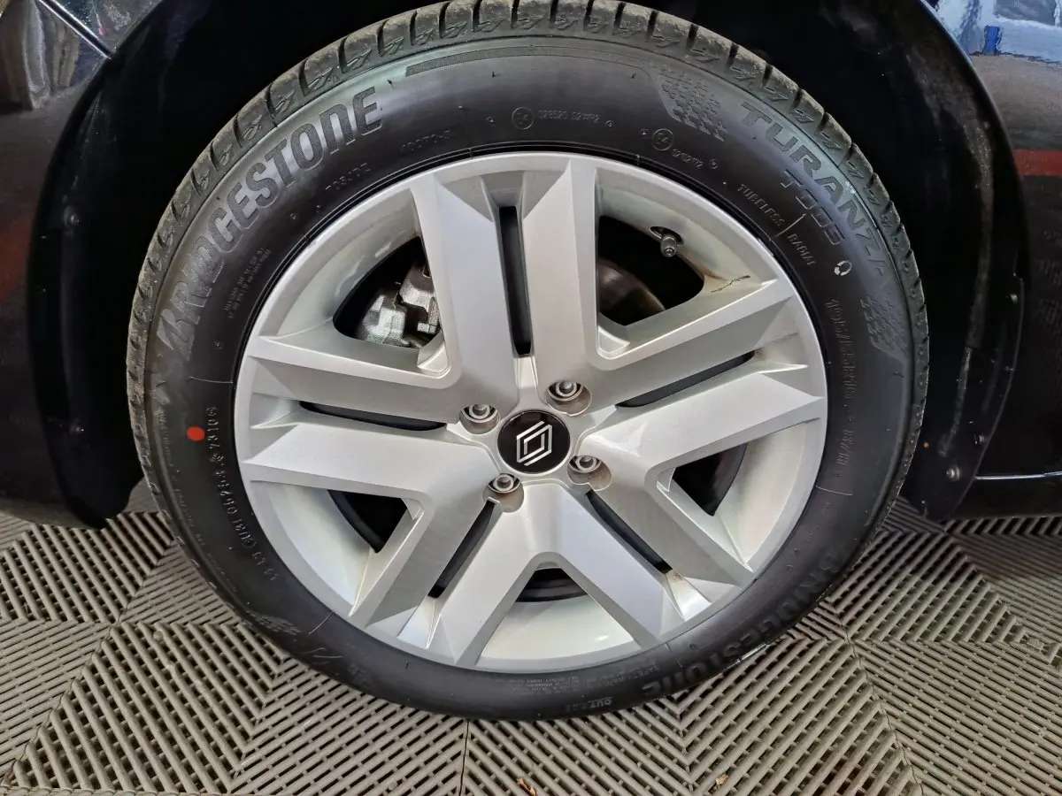 Gros plan sur la roue avant droite d'une Renault Clio noire 2025, avec jante alliage argent et pneu Bridgestone Turanza.