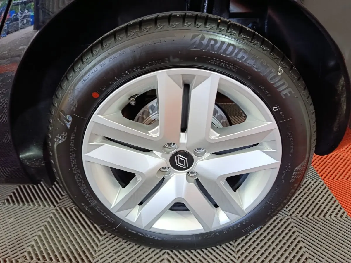 Gros plan sur la roue arrière droite noire d'une Renault Clio Evolution Blue dCi 100, avec passage de roue visible.