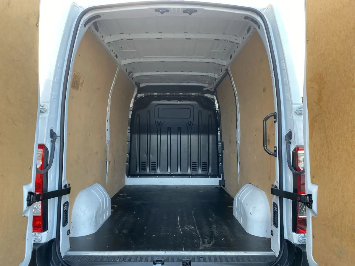 Vue arrière du Renault Master blanc 2022 montrant l’intérieur vide et spacieux de la zone de chargement avec cloison pleine noire.