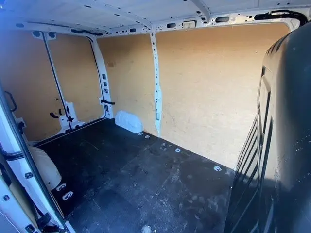 Vue intérieure arrière du Renault Master blanc 2022 montrant l'espace de chargement avec cloison pleine et plancher noir.