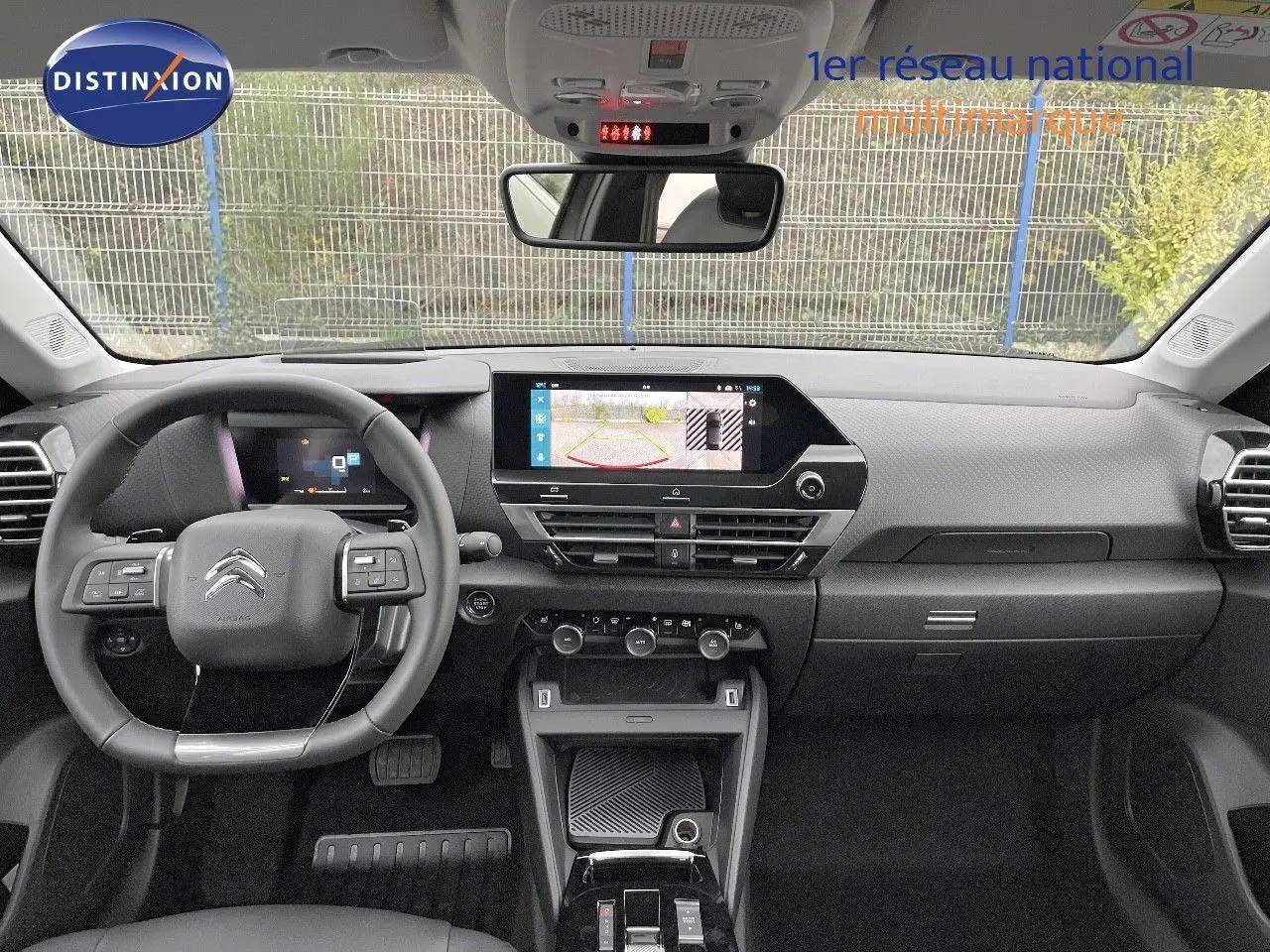 Intérieur du Citroën C4 2024 en gris, vue frontale du tableau de bord avec écran tactile et volant multifonction.