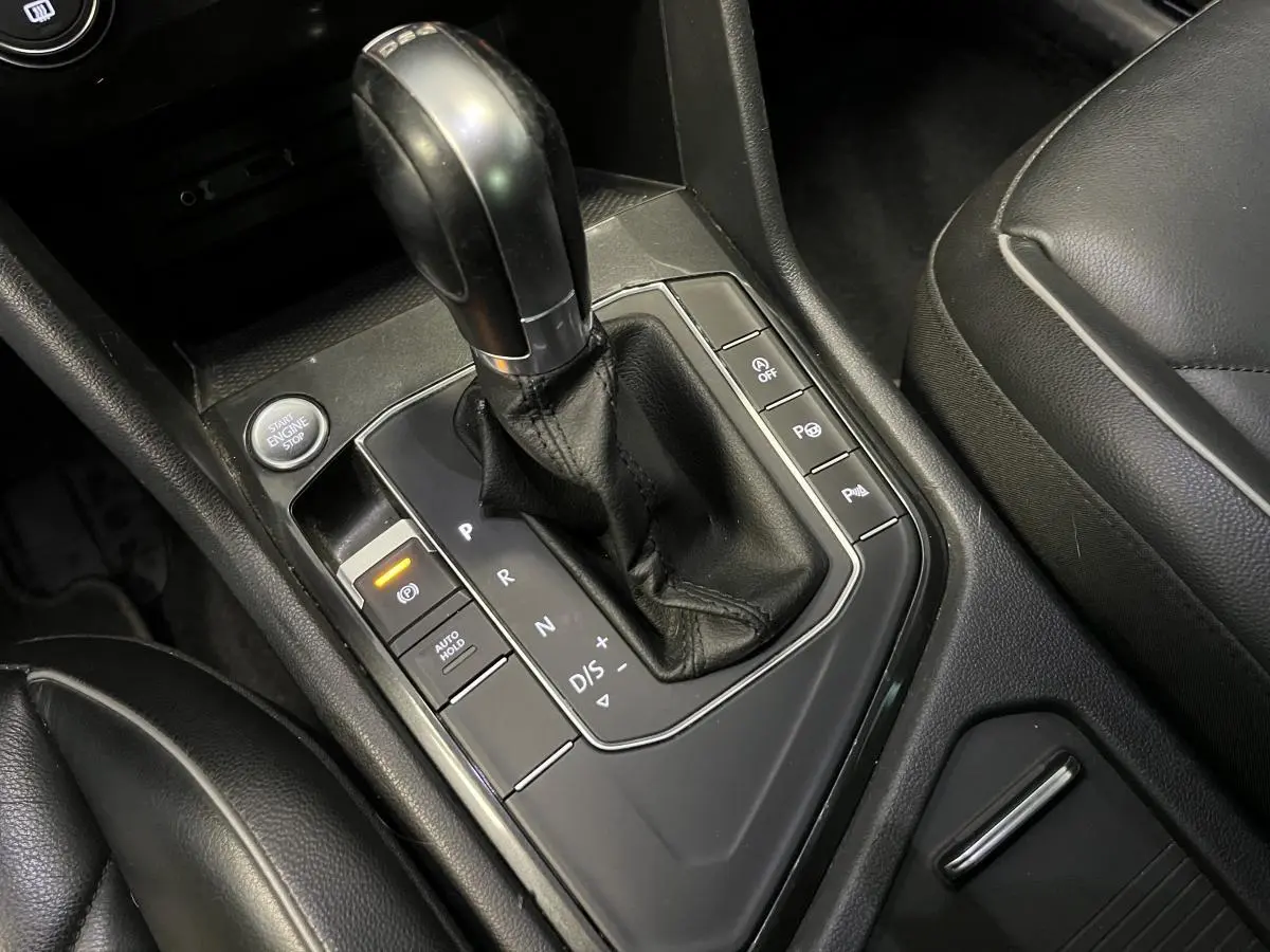 Le levier de vitesses automatique noir du Volkswagen Tiguan 2017 vu de dessus avec sièges en cuir noir.