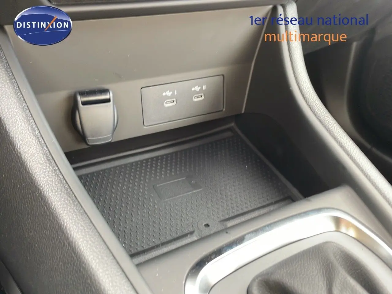 Gros plan sur la console centrale du Renault Captur E-Tech Hybrid 2025, montrant les ports USB-C et un espace de rangement noir.