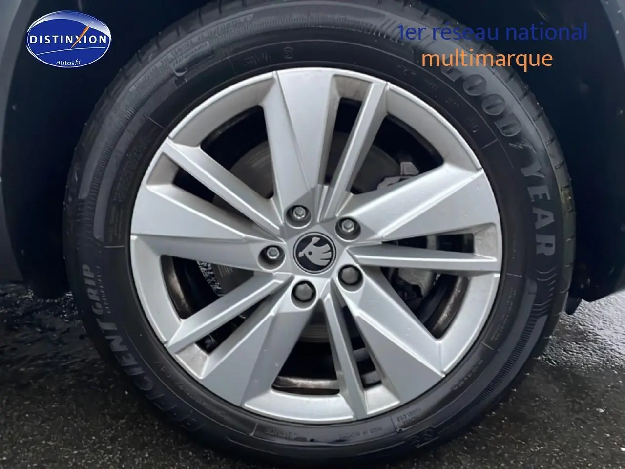 Gros plan sur la jante alu argentée d'une Skoda Karoq blanche glacial, vue côté droit, pneu Goodyear visible.