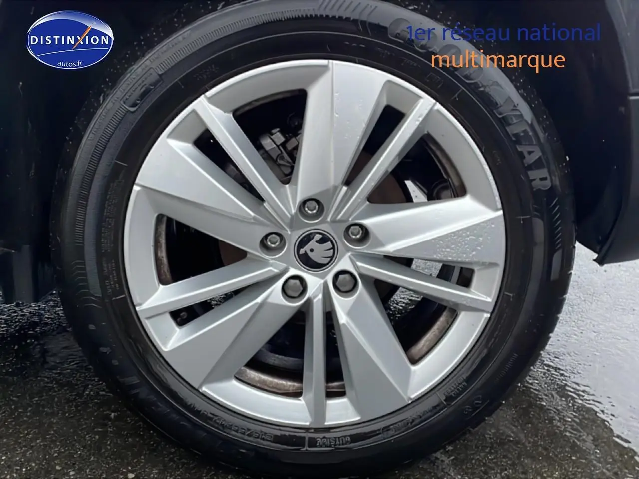 Gros plan sur la jante alu argentée d'un Skoda Karoq blanc glacial, avec pneu Goodyear visible.