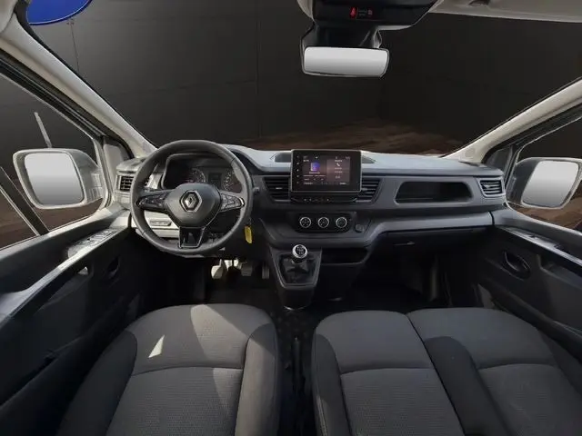 Vue intérieure avant du Renault Trafic Fourgon gris clair 2022, tableau de bord avec écran tactile et volant multifonctions.