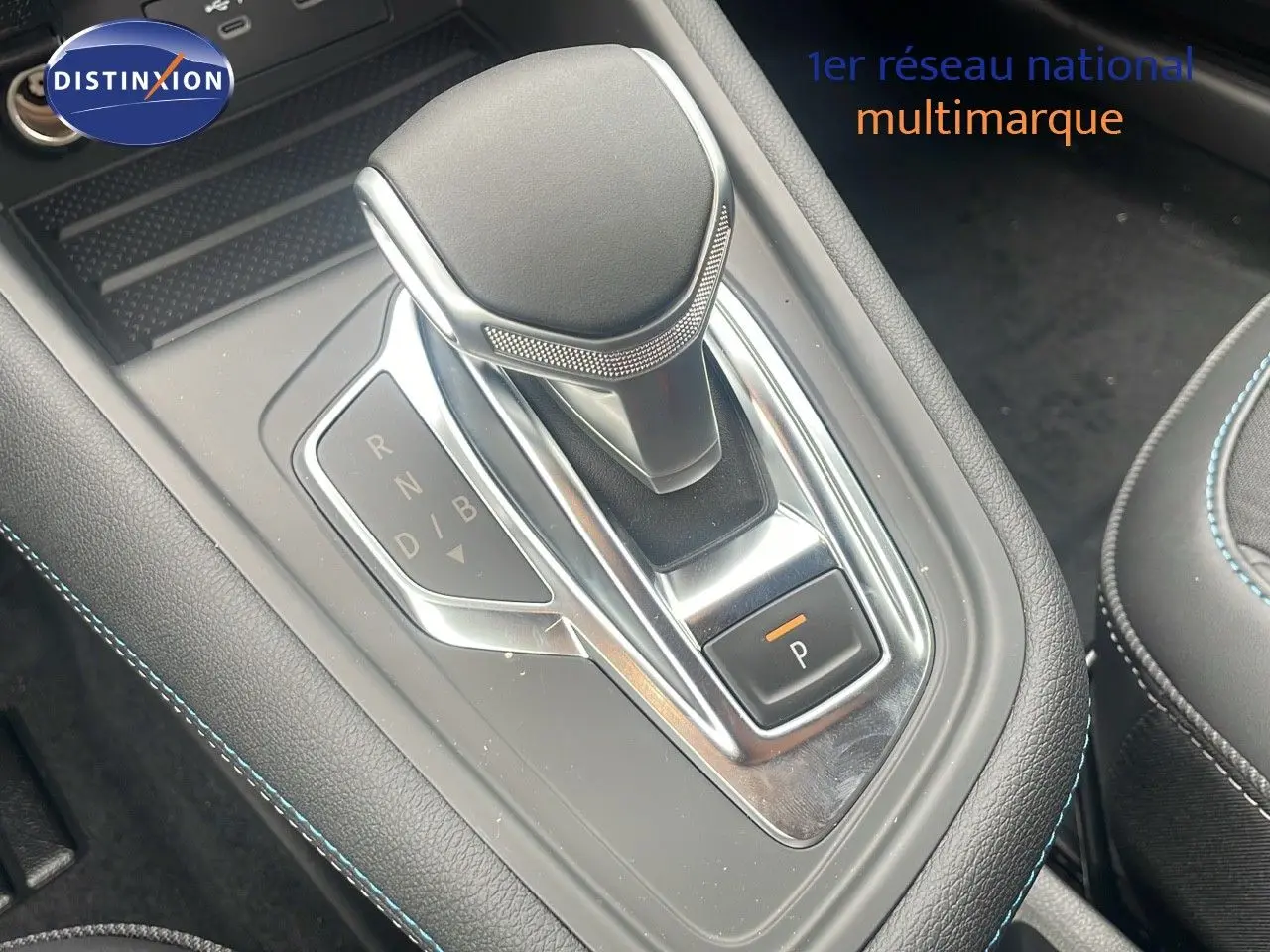 Le levier de vitesses automatique du Renault Captur E-Tech hybride, avec coutures bleues sur console noire.