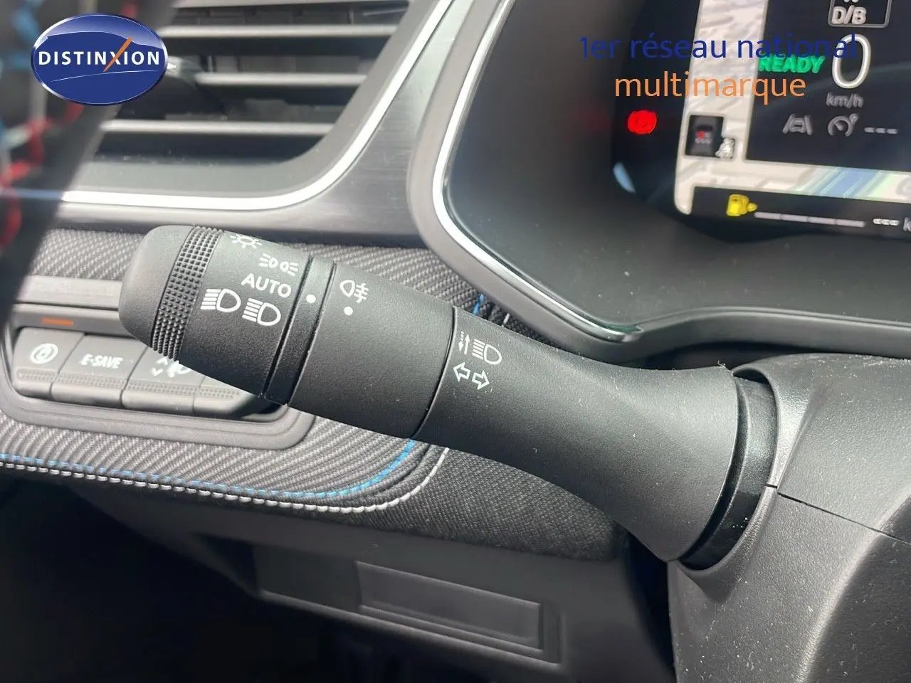 Gros plan sur la commande des feux et clignotants du tableau de bord du Renault Captur E-Tech hybride 2025.