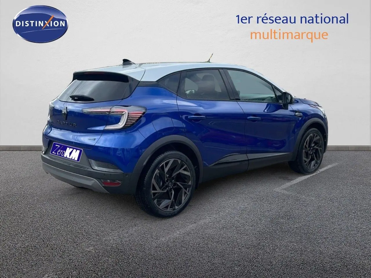 Vue 3/4 arrière droite du Renault Captur E-Tech hybride bleu Iron avec toit gris et jantes noires distinctives.