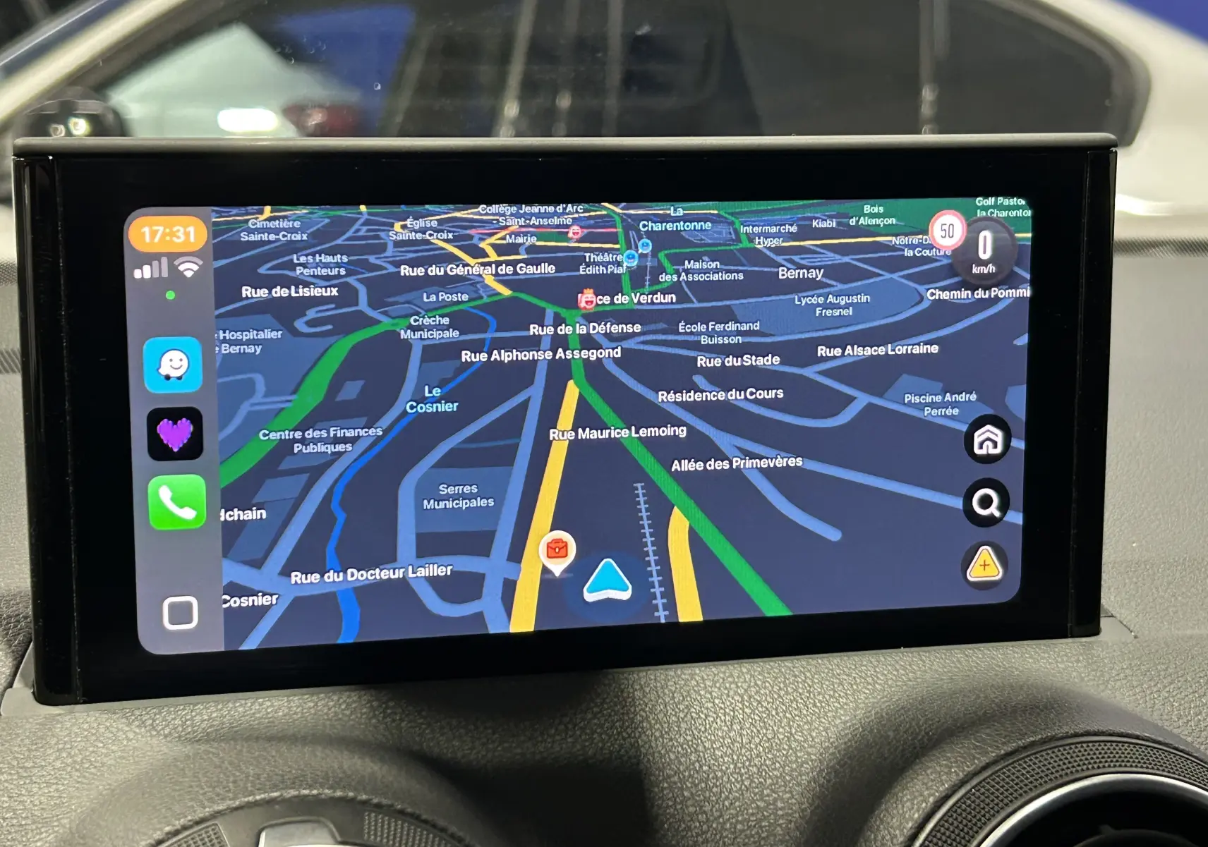 Écran de navigation affichant un Audi Q2 noir métal en 3/4 avant avec menu radio, médias et téléphone.