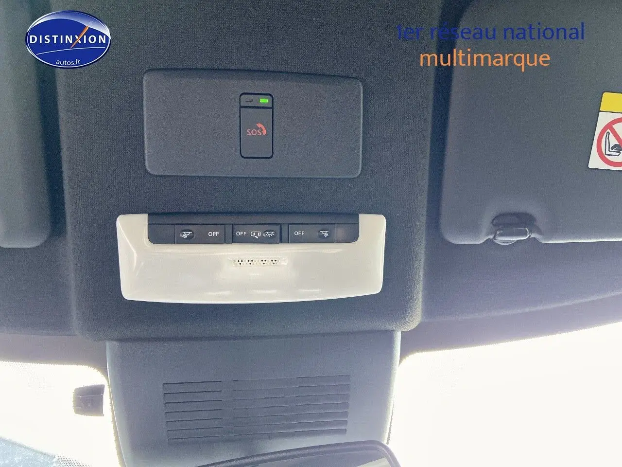 Vue intérieure du plafond avant du Nissan Juke gris clair 2021, avec commandes SOS et éclairage intégré.