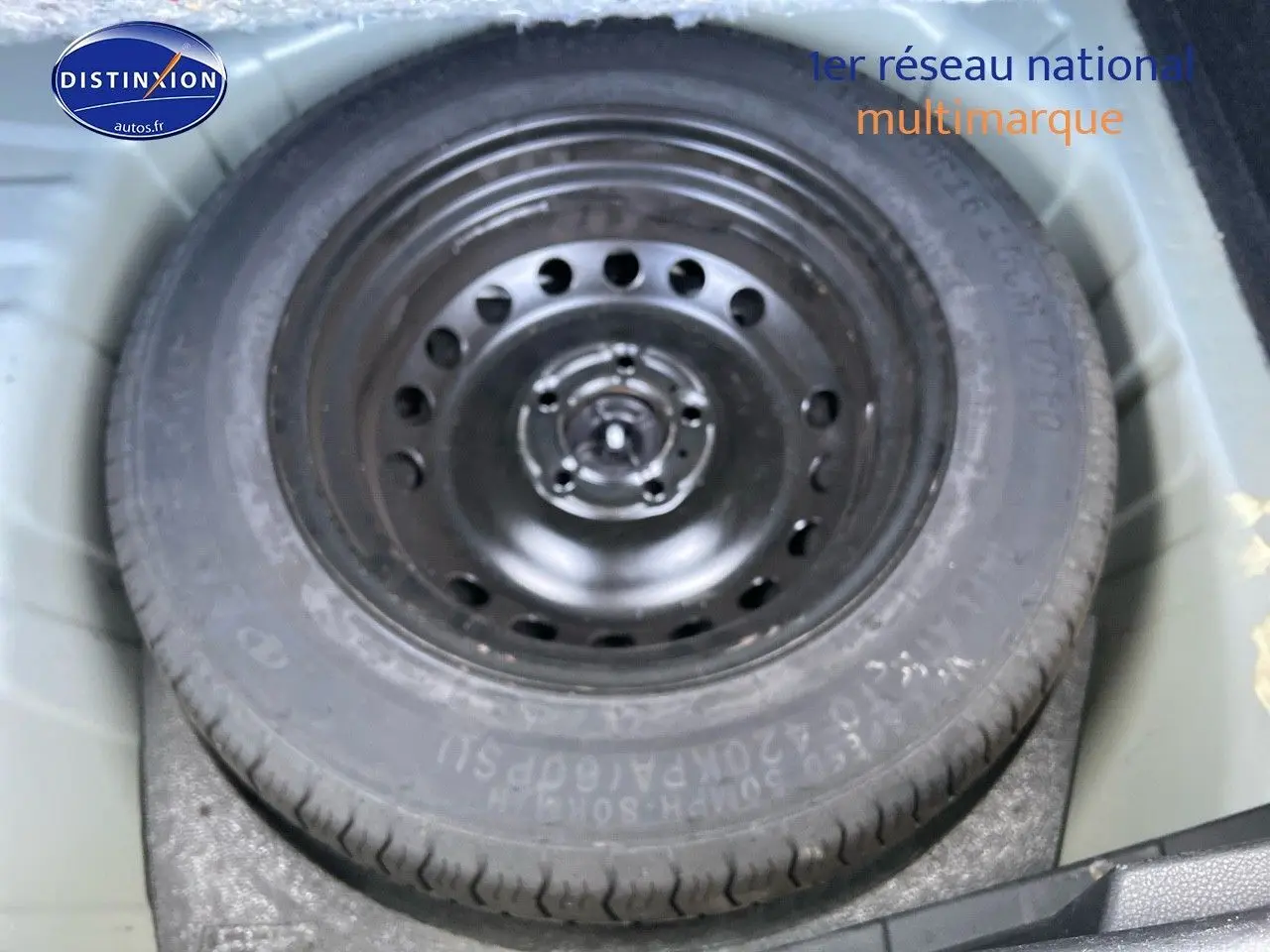 Roue de secours noire dans le coffre d'un Nissan Juke gris clair 2021, version essence automatique N-Connecta.