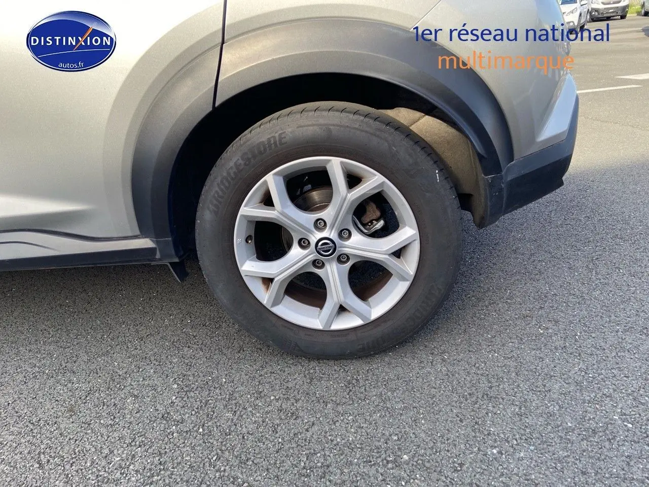 Gros plan sur la roue avant droite d'un Nissan Juke gris clair 2021 avec jante alliage à cinq branches.