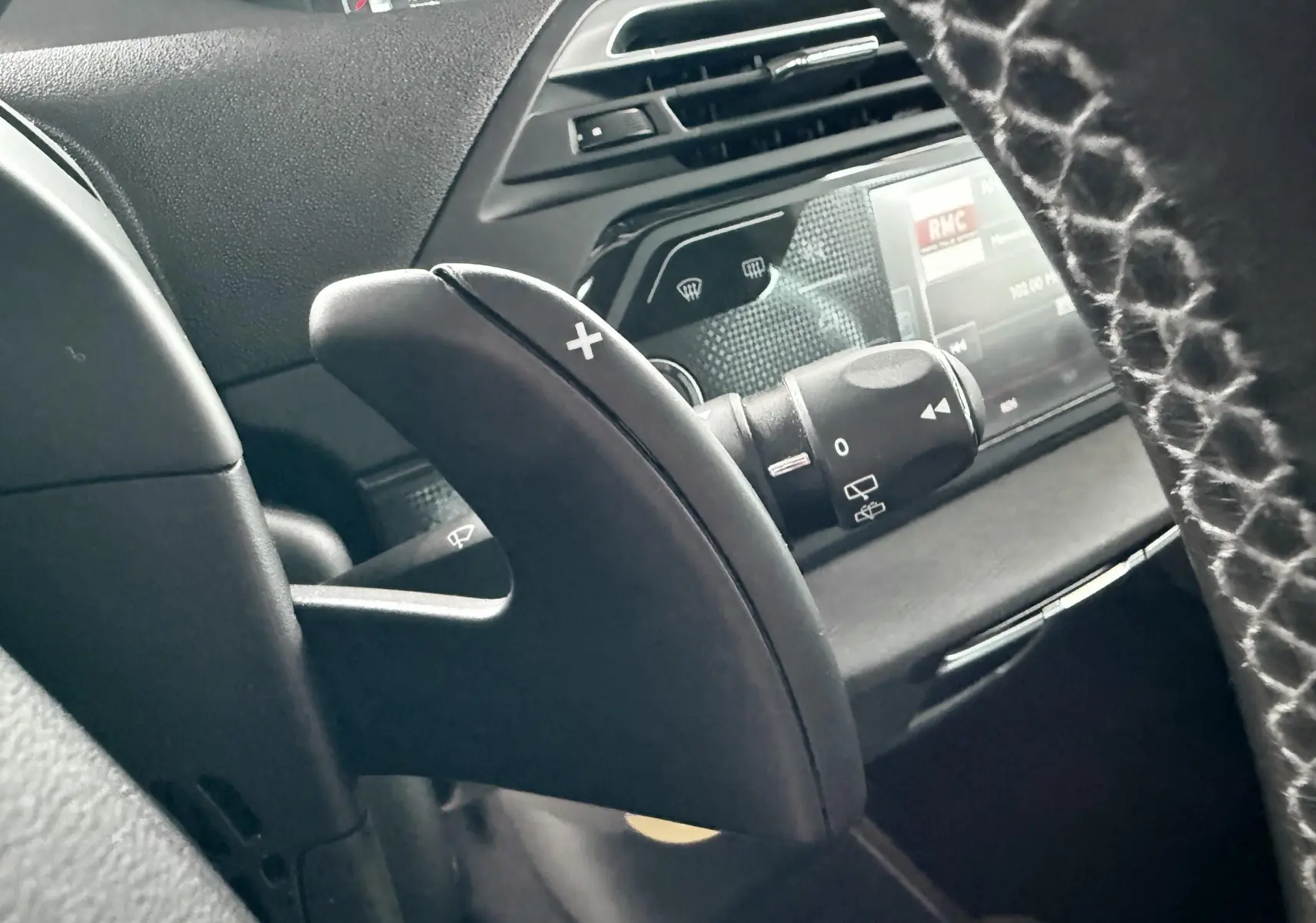 Gros plan sur la palette de changement de vitesse côté droit du volant dans l’habitacle noir du Citroën C4 Picasso 2015.