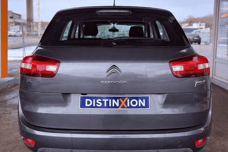 Vue arrière d'une Citroën C4 Picasso gris platinium métallisé avec feux rouges et plaque d'immatriculation Distinxion.
