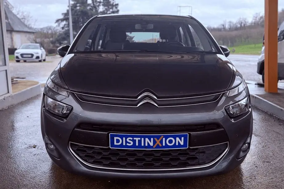 Vue frontale d'une Citroën C4 Picasso gris platinium métal avec calandre et logo distinctifs visibles.