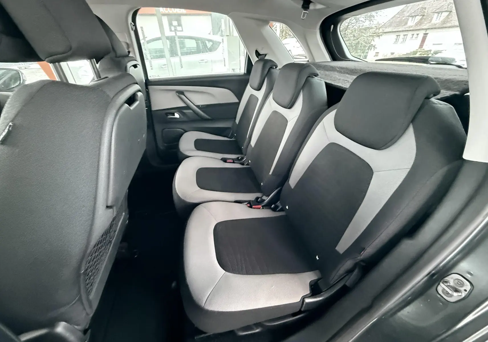 Vue intérieure côté droit des sièges arrière gris clair et noir du Citroën C4 Picasso 2015.