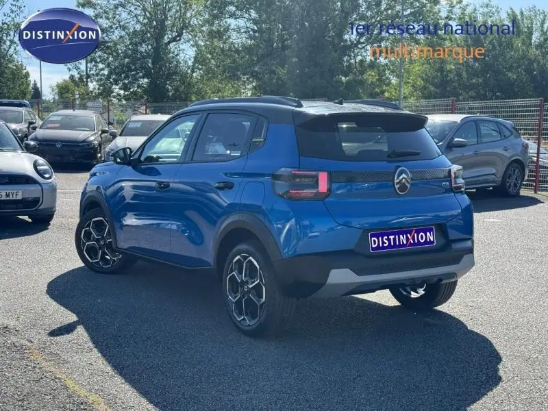 Vue 3/4 arrière droite d'une Citroën C3 2025 Bright Blue avec toit noir et jantes alu au soleil.