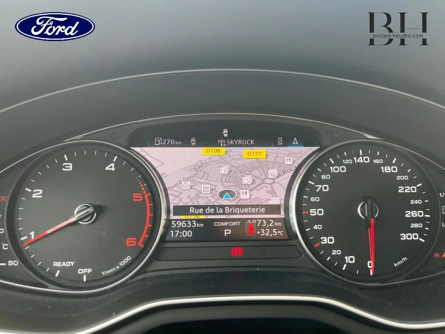 Tableau de bord numérique d'Audi A4 Avant 30 TDI gris Manhattan, affichant la navigation et compteurs à aiguille.