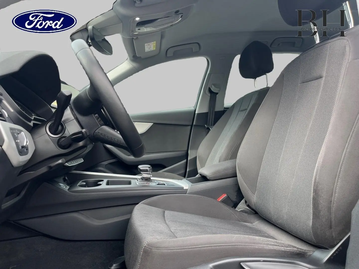 Intérieur avant droit de l'Audi A4 Avant 30 TDI 2022, sièges tissu gris et console centrale avec levier de vitesse automatique.