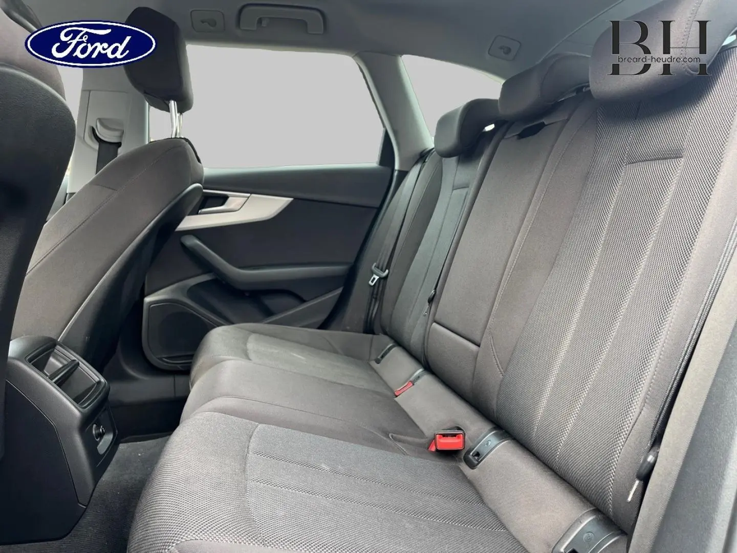 Vue intérieure arrière côté droit de l’Audi A4 Avant 30 TDI gris Manhattan, montrant la banquette tissu et les appuie-têtes.