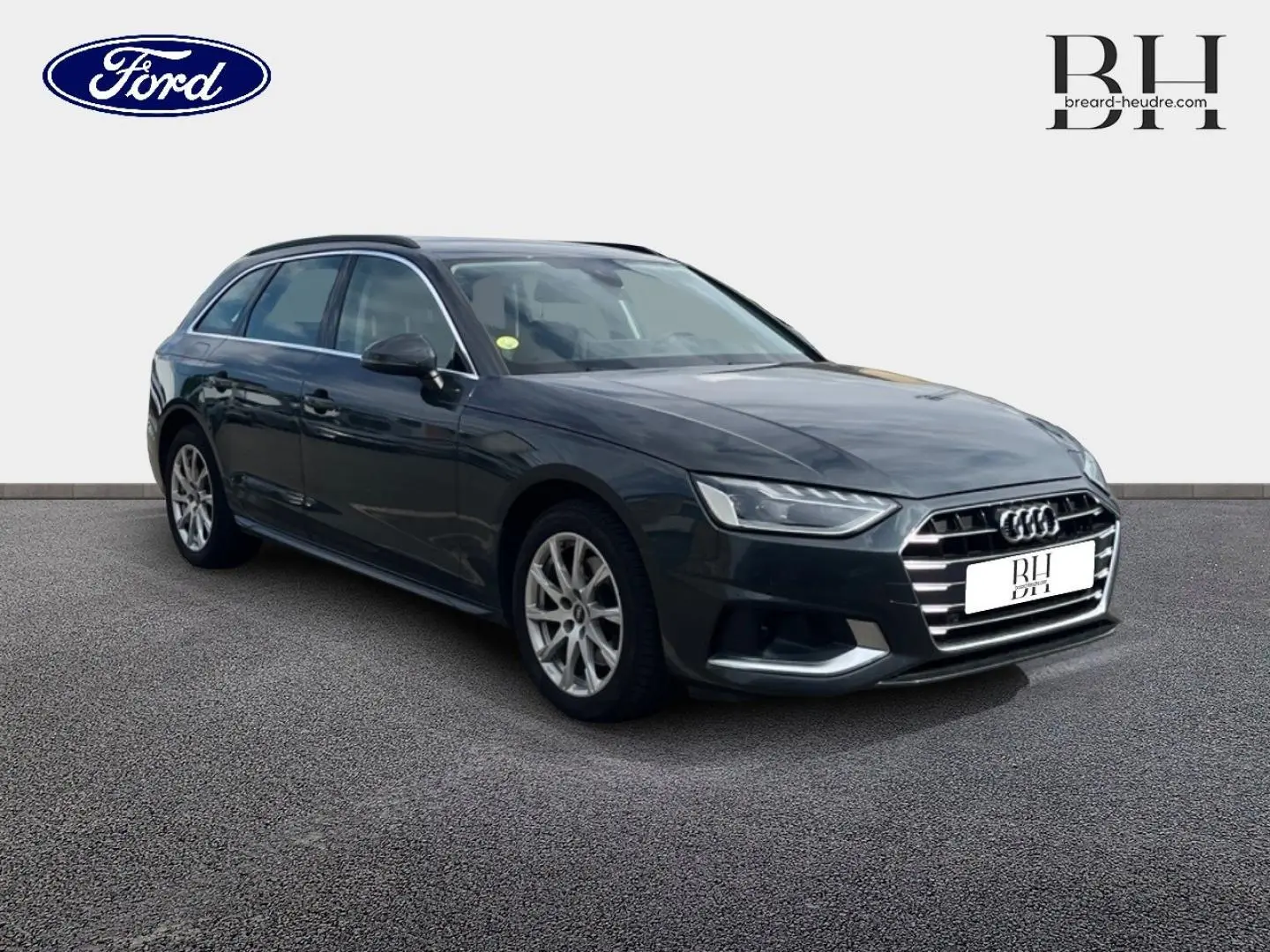Audi A4 Avant 30 TDI gris Manhattan métallisé vue 3/4 avant avec jantes alu et barres de toit noires.