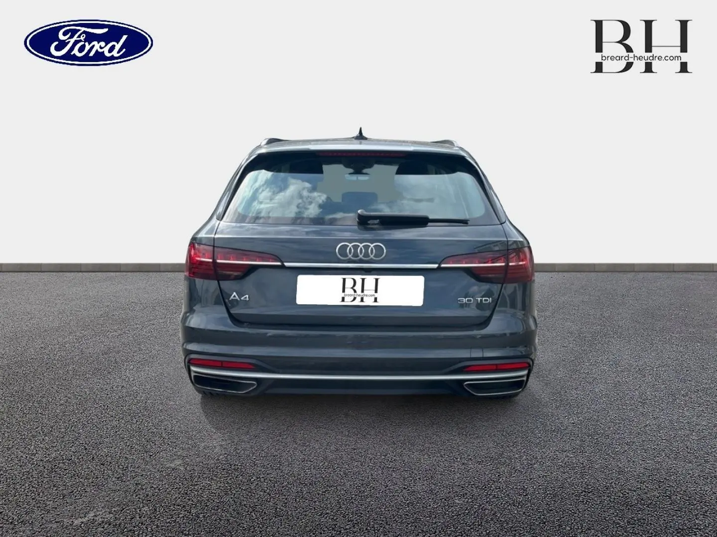 Vue arrière d'une Audi A4 Avant 30 TDI gris Manhattan métallisé, avec feux LED et double sortie d'échappement chromée.