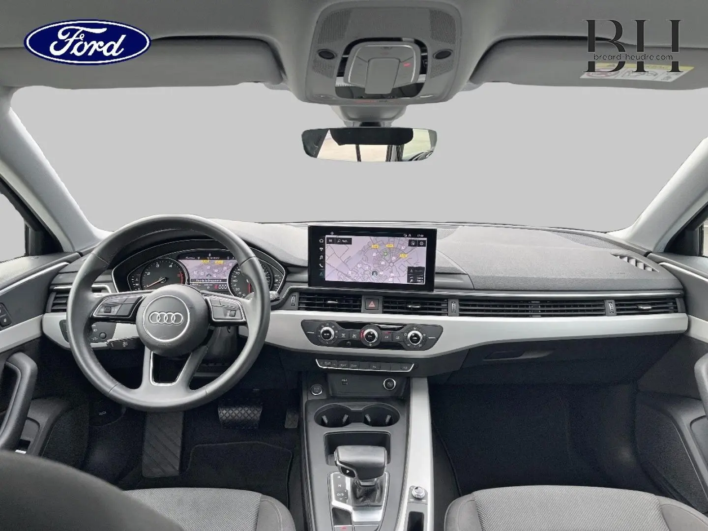 Vue intérieure frontale de l'Audi A4 Avant 30 TDI 2022, tableau de bord gris avec écran GPS central et volant multifonction.