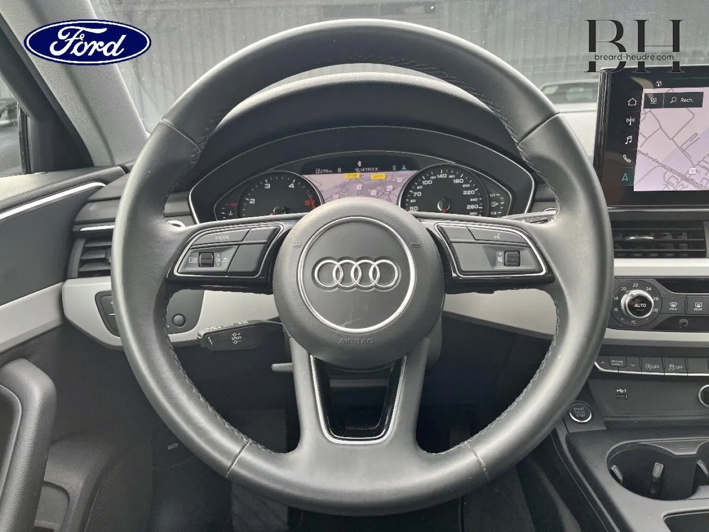 Vue centrée sur le volant cuir noir et tableau de bord numérique de l'Audi A4 Avant 30 TDI 2022.