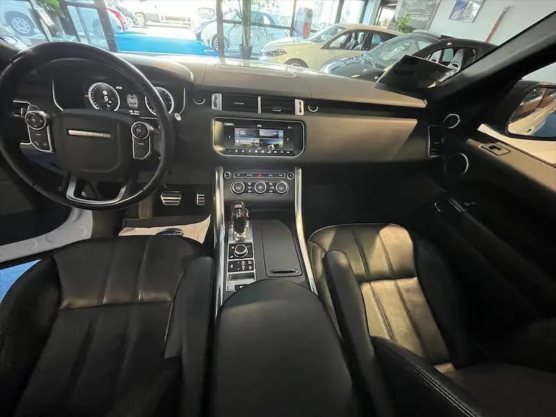Intérieur noir du Range Rover Sport 2018, vue du poste de conduite avec tableau de bord et console centrale moderne.