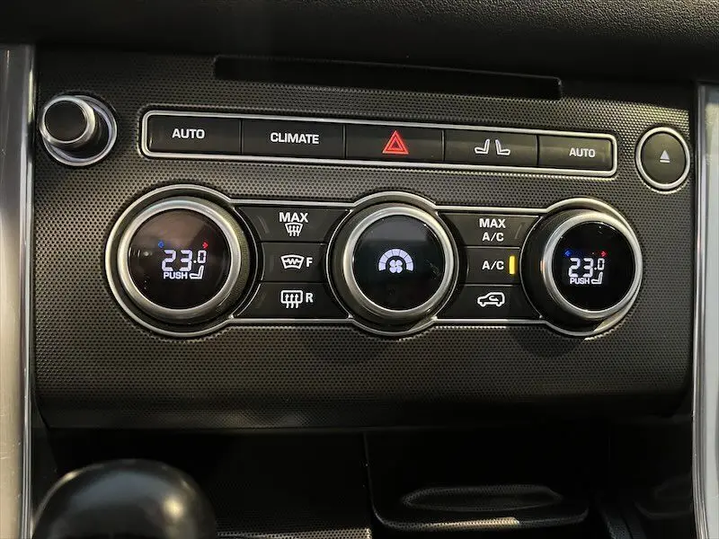 Panneau de commande de climatisation du Range Rover Sport blanc 2018, affichant 23°C et réglages automatiques.