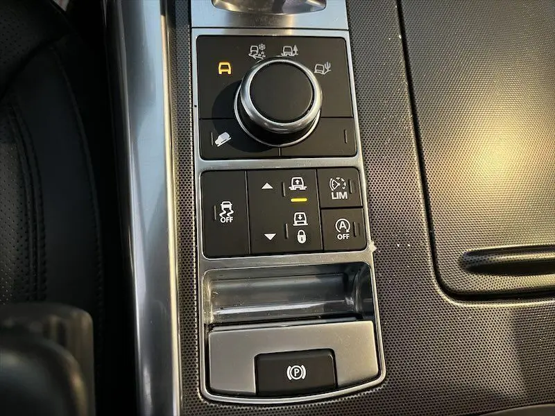 Gros plan sur la console centrale du Range Rover Sport blanc 2018, mettant en valeur les commandes de conduite et frein électronique.